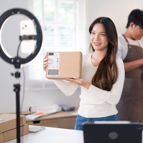 A young woman shows the behind the scenes of an unboxing to showcase a product to exemplify giving your social media followers something to gain. | Social Media Content Strategy 101 - A Blog by Hummingbird Marketing Services