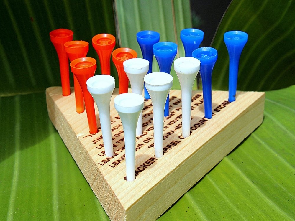 A Cracker Barrel peg game with red, white, and blue golf pegs sitting in the holes of a wooden triangle.
