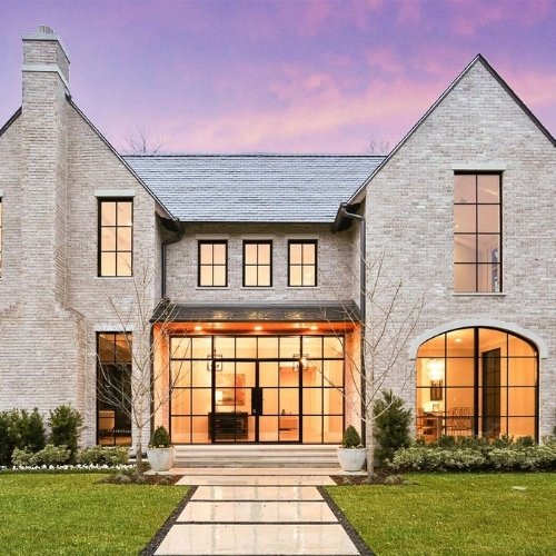 A very large home with several windows and a tidy landscaped front yard as an example of a rental house you can rent for a wedding venue.