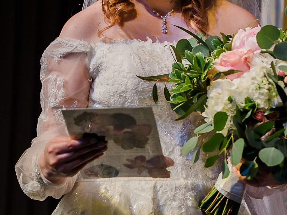 Web designer Elizabeth on her wedding day, reading her unique vows from a panel she backed with pressed flower petals.
